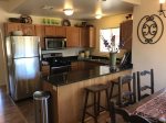 The kitchen is well-equipped with modern stainless steel appliances and updated amenities